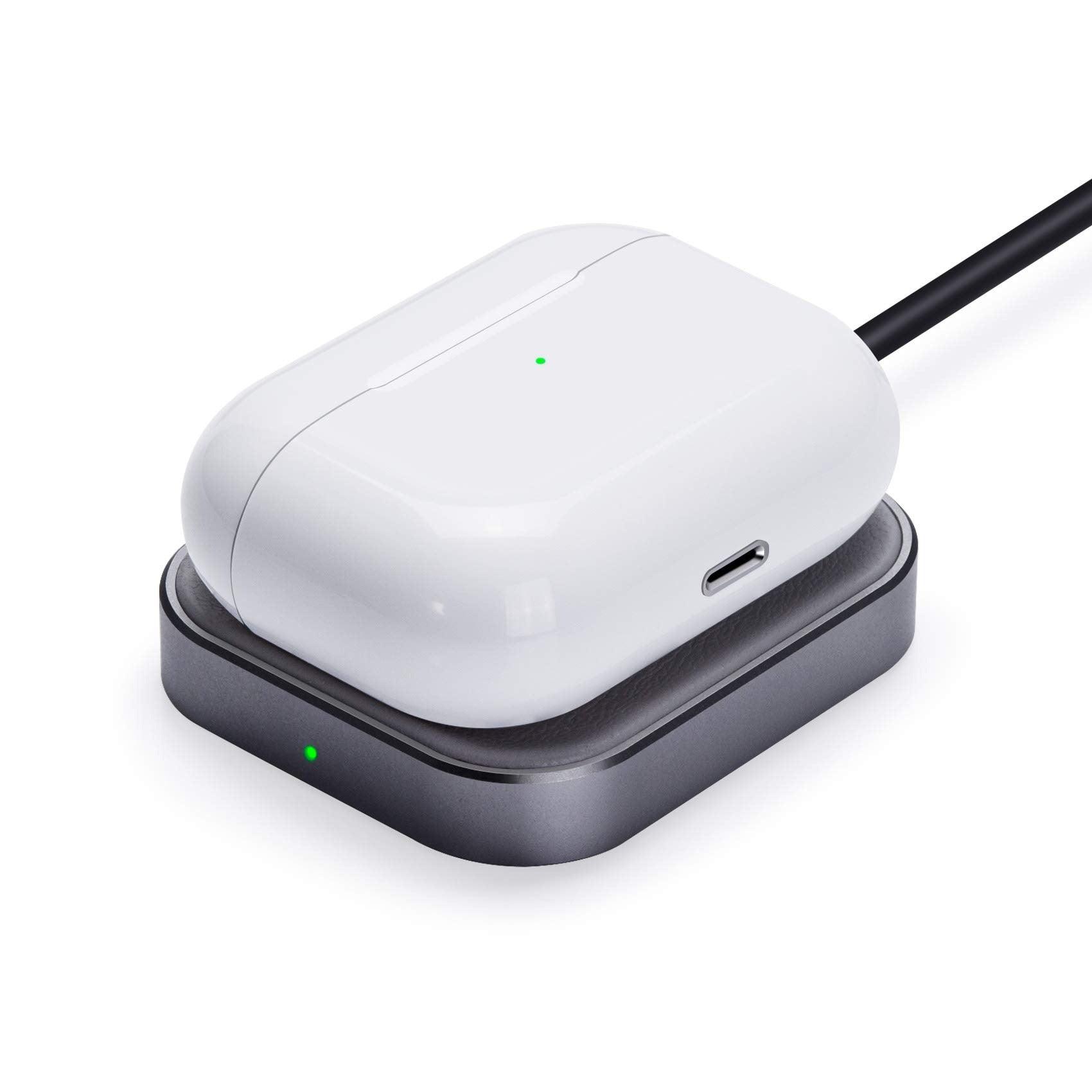 White wireless earbuds case charging on black Qi pad with green LED indicator